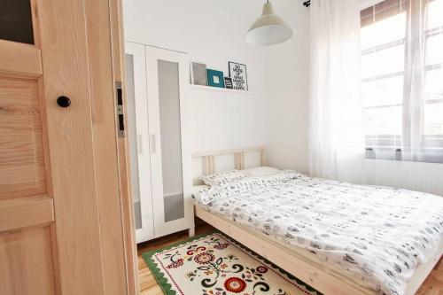 a small bedroom with a bed and a rug at Gdańsk Old Tenement Apartment Sowinskiego in Gdańsk
