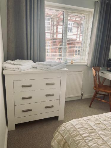 a white dresser in a bedroom with a window at Lavender House in Edwinstowe