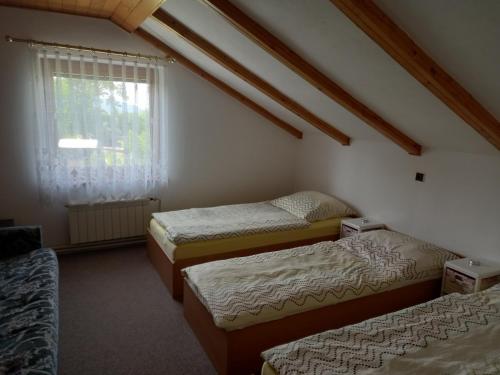 Habitación con 3 camas y ventana en Ubytování u Krpců en Lhotka