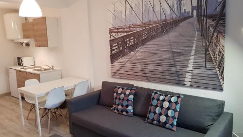 a living room with a couch and a painting of a pier at Appartement "Gabrielle" au calme en Hypercentre de Revel in Revel