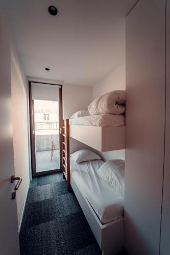 a room with three bunk beds and a window at Casino Hotel in Koksijde