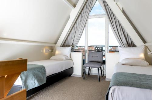 two beds in a room with a window at Martin's Brugge in Bruges