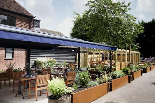 a patio with tables and chairs and plants at Bel and The Dragon at Red Lion Wendover in Wendover