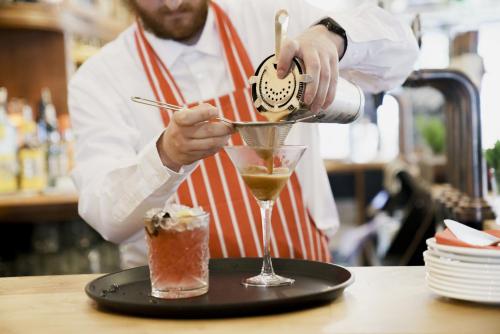 a man pouring a drink into a martini glass at Bel and The Dragon at Red Lion Wendover in Wendover