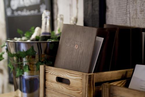 a wooden box filled with books on a table at Bel and The Dragon at Red Lion Wendover in Wendover
