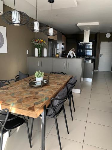 a kitchen and dining room with a wooden table and chairs at CAG The Hub Bryanston in Johannesburg