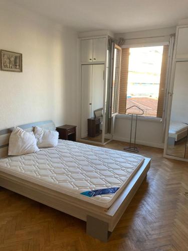 un grand lit dans une chambre avec une grande fenêtre dans l'établissement La finestra sul mare, à Antibes