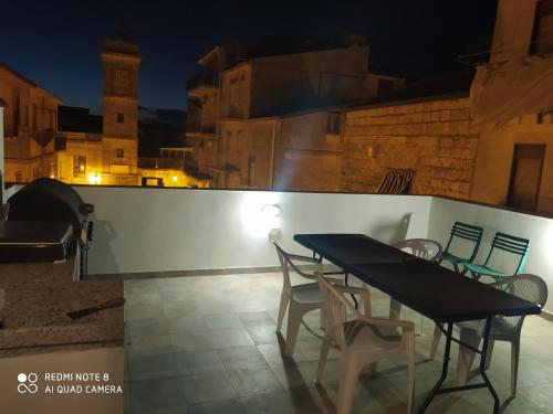 a table and chairs on a balcony at night at bed & breakfast Acquaviva di Vullo Vincenzo in Acquaviva Platani