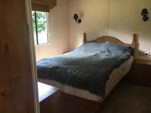 1 cama en un dormitorio con ventana en Domek na Trylkówku en Szczytno