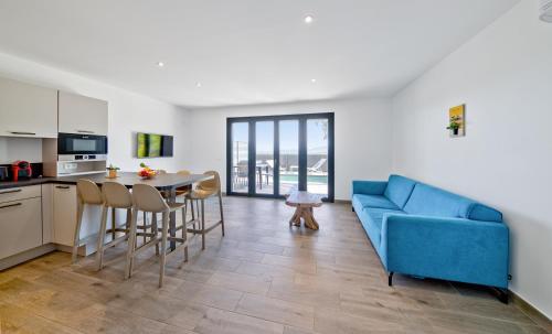 a living room with a blue couch and a table at Résidence Pierre & Vacances Premium Les Terrasses d'Arsella in Porto-Vecchio