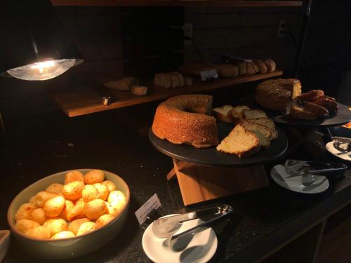 a buffet with several plates of bread and pastries at Novotel BH Savassi in Belo Horizonte