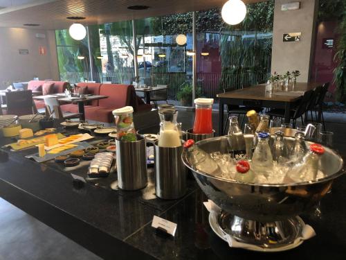 a restaurant with a counter with food on it at Novotel BH Savassi in Belo Horizonte