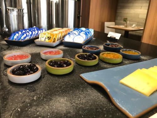 a counter with bowls of different types of food at Novotel BH Savassi in Belo Horizonte