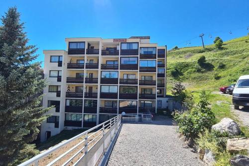 a building on a hill with a car parked in front at Très joli studio au calme et bien situé in Orcières