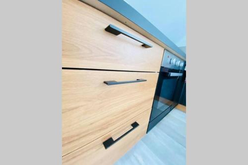 a wooden drawer with black handles in a kitchen at Appartement Jolie vue in Laon