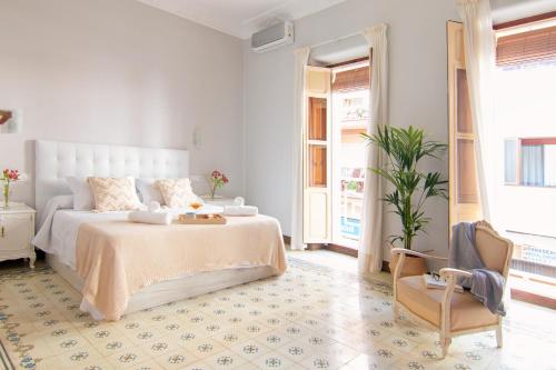貝尼薩的住宿－Casa Casanova，白色卧室配有床和椅子