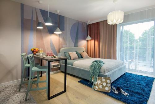 1 dormitorio con cama, mesa y comedor en W&K Apartments - Joy Suite, en Koszalin