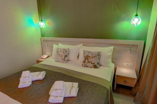 a bedroom with a bed with two slippers on it at Savaneti Eco Hotel in Tʼelavi