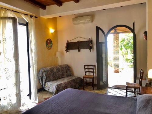ein Schlafzimmer mit einem Bett, einem Stuhl und einem Fenster in der Unterkunft Villa Almoezia Charming B&B in Taormina