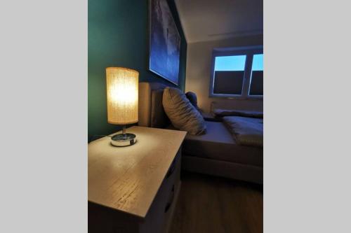 a room with a table with a lamp and a couch at Sanierte 2 ZKB Fewo - Top Lage - PayTV und WLAN in Wilhelmshaven