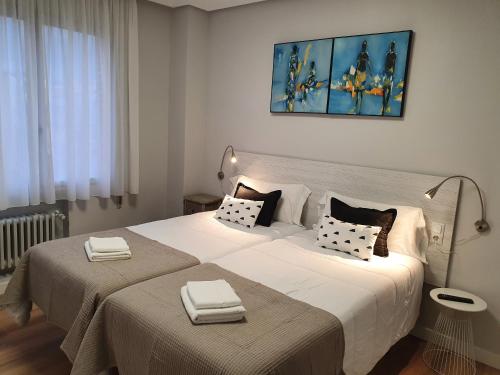 a bedroom with a large bed with two towels on it at Pensión Muro de la Mata in Logroño