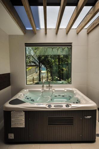 a jacuzzi tub in a room with a window at Infinity Resort in Puerto Galera