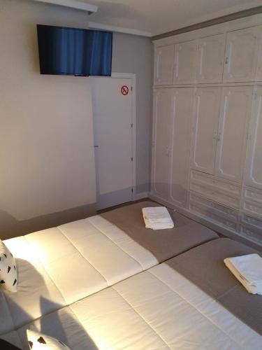 Cette chambre comprend deux lits et un placard. dans l'établissement Pensión Espolón De Logroño, à Logroño