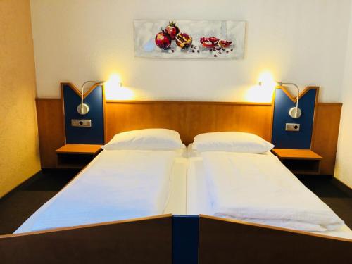 two twin beds in a room with two lights at Pension Marktplatz Rüsselsheim in Rüsselsheim