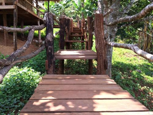 a wooden path leading to a tree house at Tree Lodge in Sen Monorom