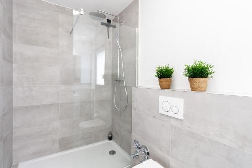 uma casa de banho com um chuveiro, um lavatório e uma banheira em Modernes Apartment *Liobablick Nr. 2* - FeWo in Fulda/Petersberg em Petersberg
