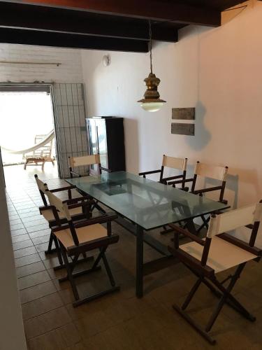 a dining room with a glass table and chairs at Casa Beira Mar Itamaracá in Itamaracá