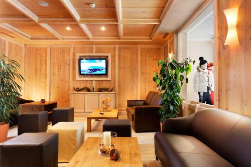 a living room with a couch and a table at Hotel Auwirt Zentrum in Saalbach-Hinterglemm