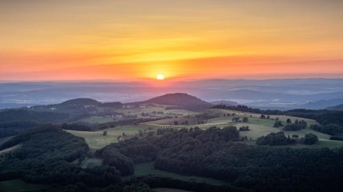 a painting of a sunset over a valley with trees at Modernes Apartment *Liobablick Nr. 3* - FeWo Fulda/Petersberg in Petersberg