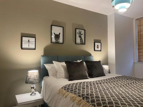ein Schlafzimmer mit einem Bett mit vier Bildern an der Wand in der Unterkunft Central Apartment - Moderna in Blairgowrie