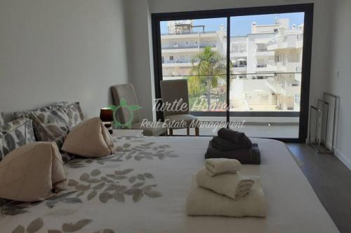 un soggiorno con un grande letto con cuscini sopra di Luxury penthouse with private roof terrace a Tavira