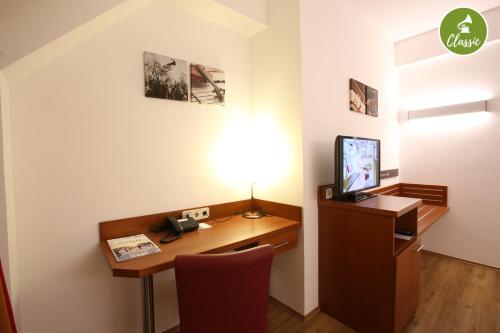 an office with a desk with a computer and a phone at arte Hotel Wien Stadthalle in Vienna
