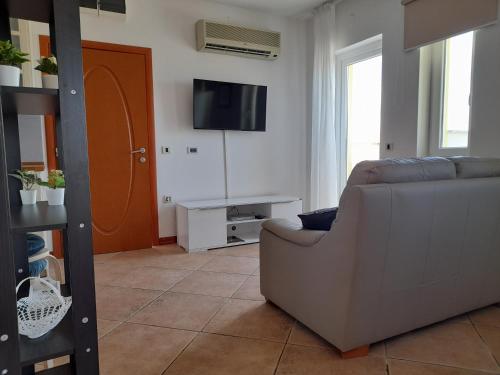 a living room with a couch and a flat screen tv at Hotel Manora in Nerezine