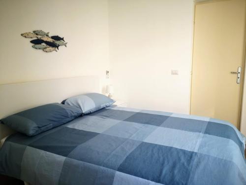 a bed in a room with a blue blanket on it at Suite On Fish Market in Catania