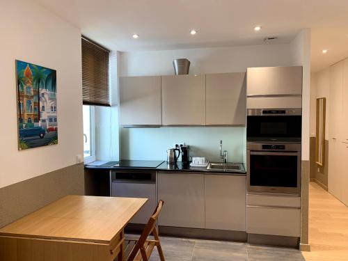 cocina con electrodomésticos de acero inoxidable y mesa de madera en Share Inn Appartements, en Niza