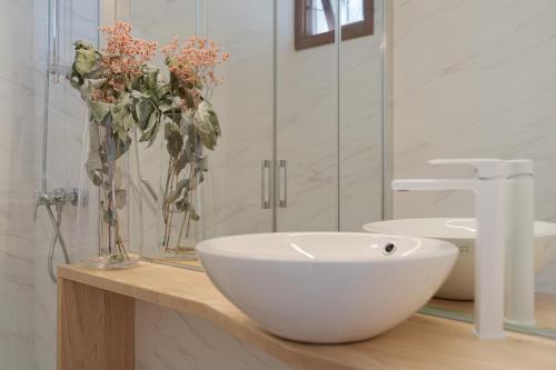 baño con lavabo y jarrón con flores en Alsol Las Orquídeas, en Playa del Inglés