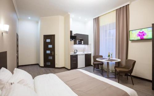 a hotel room with a bed and a table and a kitchen at Khreshchatyk Apart Hotel 911 in Kyiv