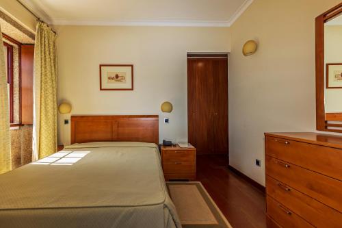 a bedroom with a large bed and a dresser at Hotel Rural Quinta de Sao Sebastiao in Barroselas