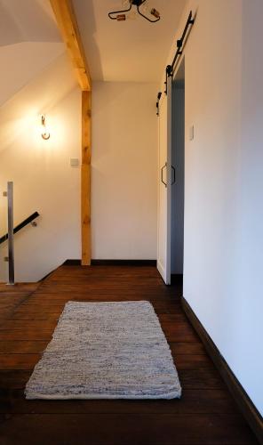a hallway with a rug on the floor and an open door at Stay At This Magnificent 100 Year Old Barn in Ruciane-Nida