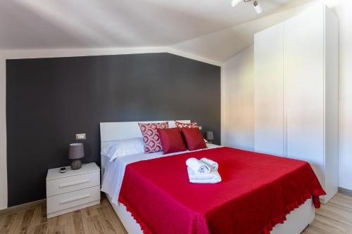 a bedroom with a large bed with a red blanket at Cadoni Guest House in Bosa