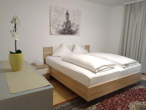 - une chambre avec un lit et une table avec un vase dans l'établissement Appartements am Kirchplatz, à Fulpmes