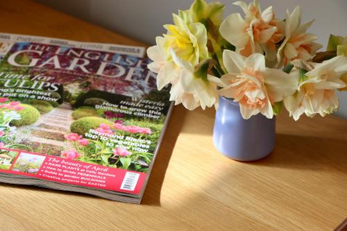 a book and a vase of flowers next to a magazine at The New Inn Halse in Taunton