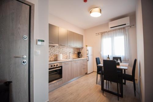 a kitchen with a table and chairs and a dining room at NIKI'S apartments in Perea