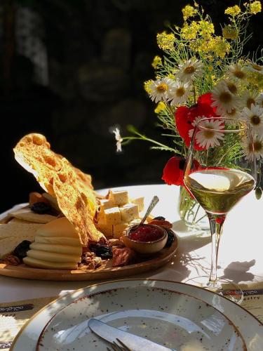a plate of cheese and bread on a table with a glass of wine at Savaneti Eco Hotel in Tʼelavi