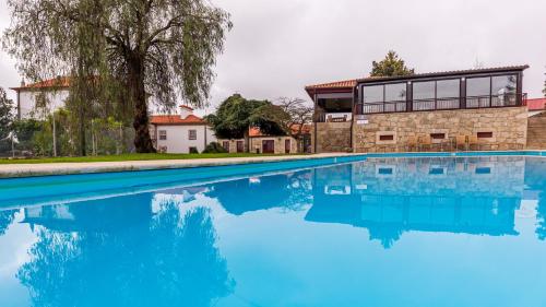 a large swimming pool in front of a house at Hotel Rural Quinta de Sao Sebastiao in Barroselas
