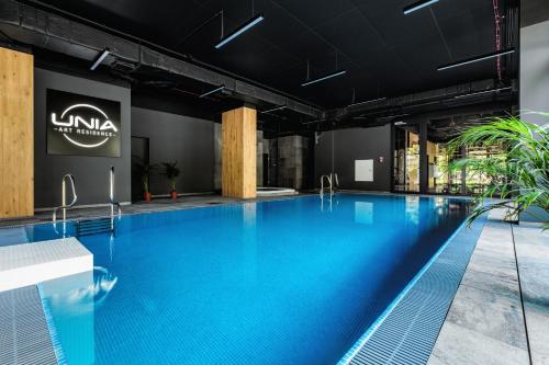 a large swimming pool with blue water in a building at PLATiNIUM RESIDENCE&SPA BASEN-SAUNA "BEST VIEW" CENTER in Lublin